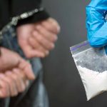 Person arrested and another person holding a bag of drugs