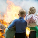 People standing in front of a fire