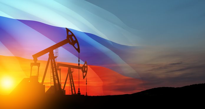 Oil rigs with Russian flag at sunset background