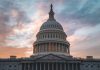 Capitol building under cloudy sunset sky