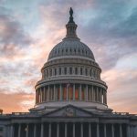 Capitol building under cloudy sunset sky