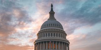 Capitol building under cloudy sunset sky