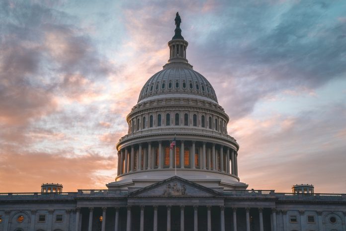 Capitol building under cloudy sunset sky