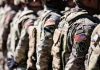 Soldiers in formation wearing camouflage and American flag patches