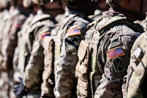 Soldiers in formation wearing camouflage and American flag patches