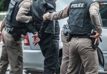 Police arresting a person by a car