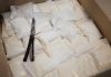Bags of white powder with scissors in cardboard box