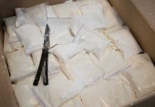 Bags of white powder with scissors in cardboard box