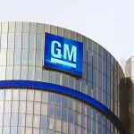 Glass building with large GM logo on top