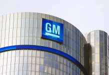 Glass building with large GM logo on top