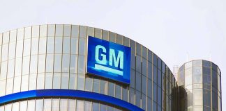 Glass building with large GM logo on top