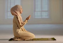 Woman praying indoors on a prayer mat