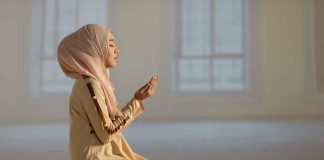 Woman praying indoors on a prayer mat