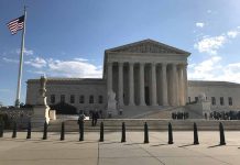 Supreme Court building with flag and people outside
