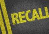 Yellow RECALL text on asphalt background