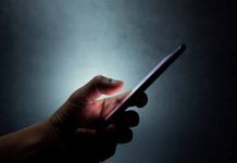 Hand holding a smartphone in dim light