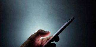 Hand holding a smartphone in dim light