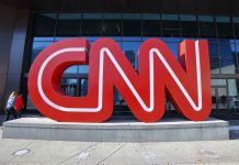 Large red CNN sign outside building entrance