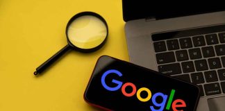 Magnifying glass laptop and smartphone displaying Googles logo