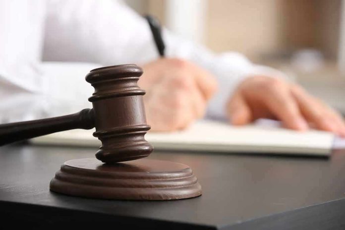 2454469737 featured image Judges gavel on desk with person writing