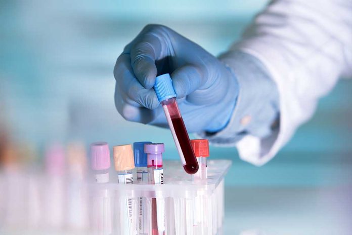441264445 featured image Gloved hand holding a blood sample test tube