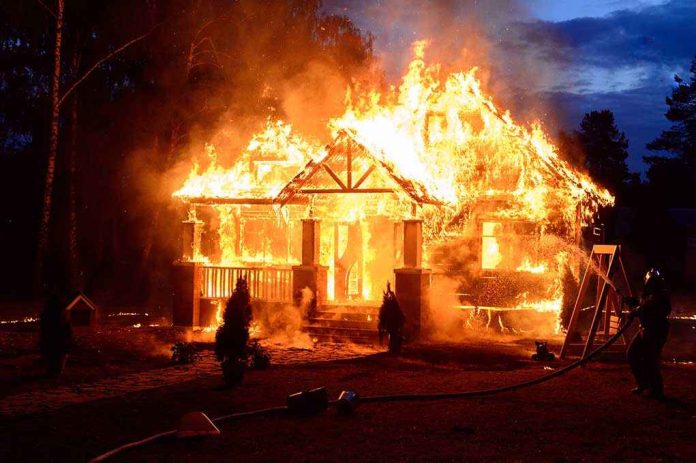 House engulfed in flames with firefighters present