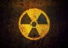 Yellow radiation warning symbol on rusty metal surface