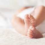 Closeup of baby feet lying on blanket