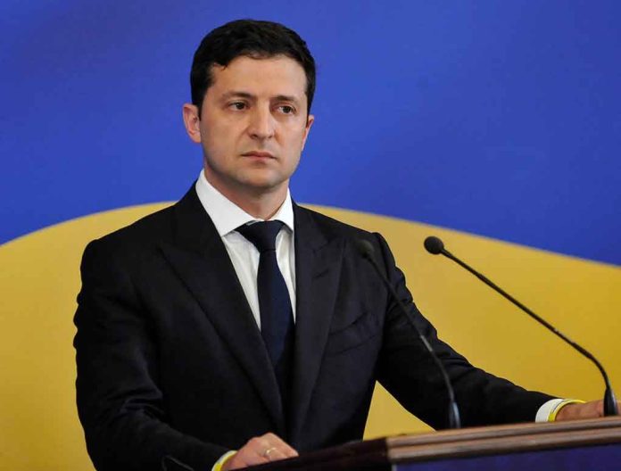 1448861675 Man in suit speaking at podium with microphones