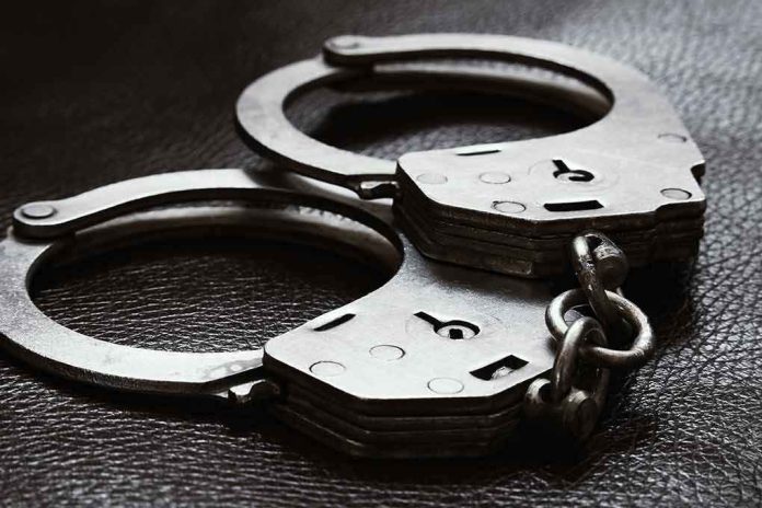 2385593779 Close up of metal handcuffs on a dark surface