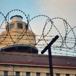 Barbed wire in front of a prison tower