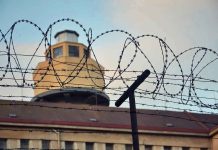 Barbed wire in front of a prison tower