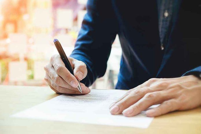 613375877 Person signing a document with a pen