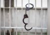 Handcuffs hanging on white metal bars