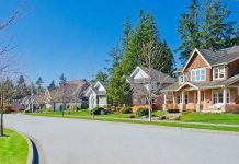 A sunny suburban neighborhood with houses and green lawns