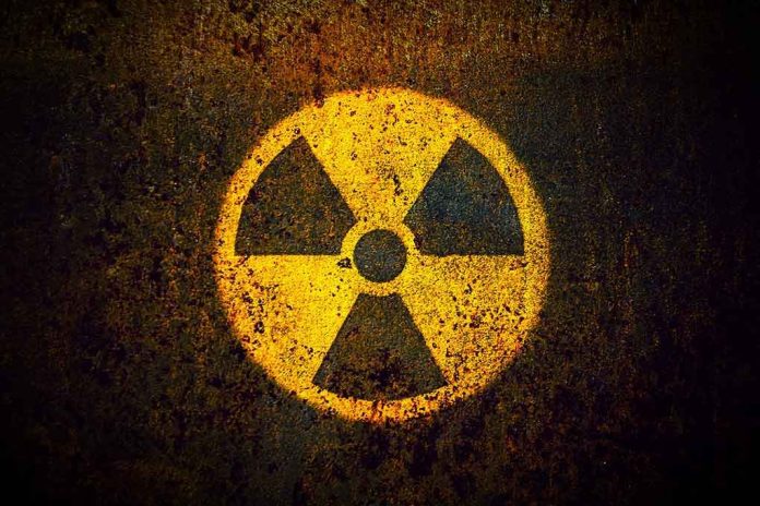 1082372921 Yellow radiation warning symbol on rusty metal surface