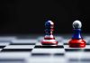 Two chess pawns painted as American and Russian flags
