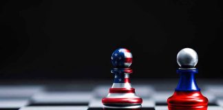 Two chess pawns painted as American and Russian flags