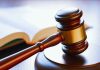 Gavel resting on sounding block beside open book