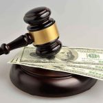 gavel resting on 100 dollar bills