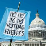 Sign reading "Voting Rights" in front of Capitol building.