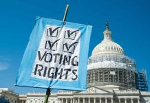 Sign reading "Voting Rights" in front of Capitol building.
