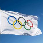 Olympic flag waving against clear blue sky