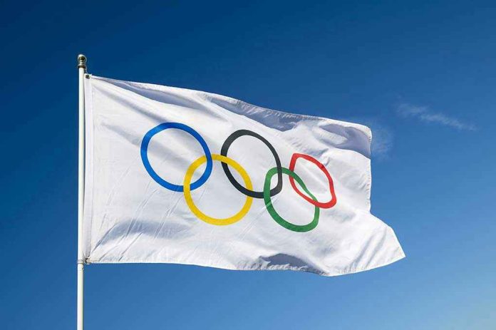 430080421 Olympic flag waving against clear blue sky