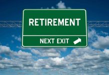 Green road sign reading retirement next exit sky background