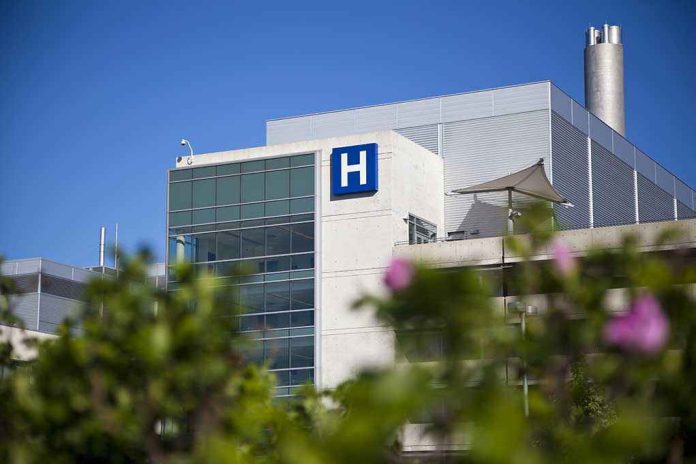 Modern hospital building with a prominent 'H' sign against a clear blue sky