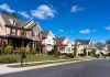 A row of modern suburban houses under a clear blue sky