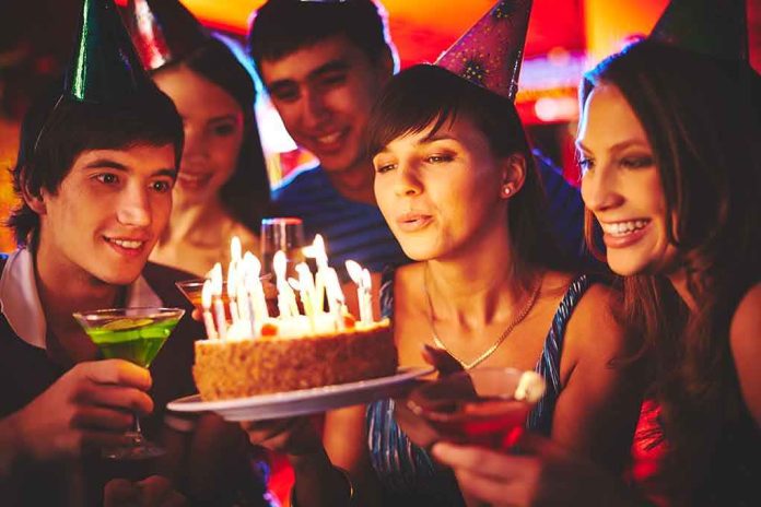 Group of friends celebrating a birthday with a cake and drinks