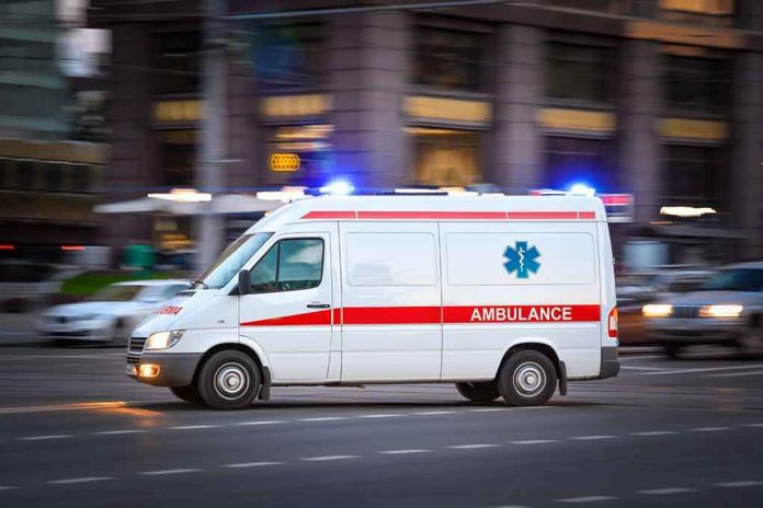 Ambulance driving on urban street with lights flashing.
