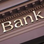 Gold bank sign on building facade